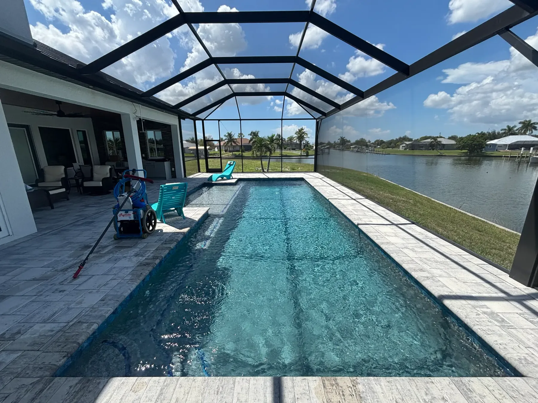 Clear screened-in waterfront swimming pool cared for by FlowState Pool Service